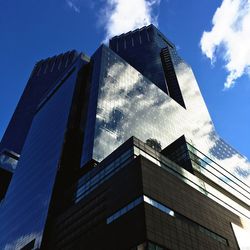 Low angle view of modern building against blue sky