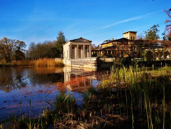 Lake by building against sky