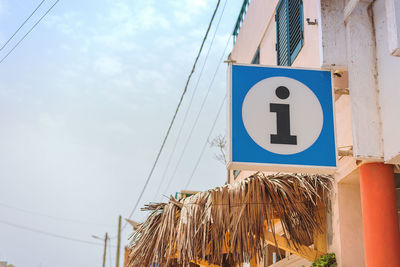 Low angle view of information sign against blue sky