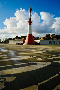 Lighthouse amidst buildings against sky