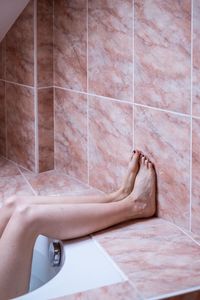 Low section of woman resting in bathroom