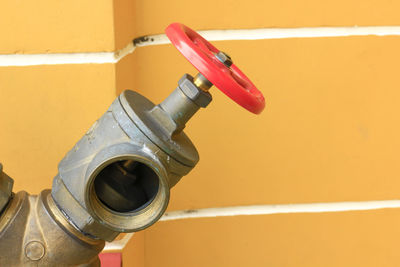 Close-up of machine valve against wall