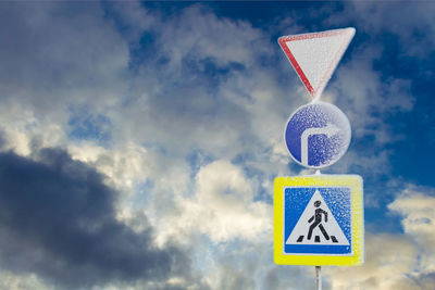 Low angle view of road sign against blue sky