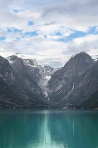 Scenic view of lake and snowcapped mountains against sky