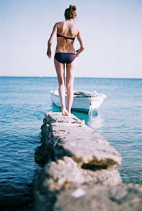 Rear view of young woman standing on beach