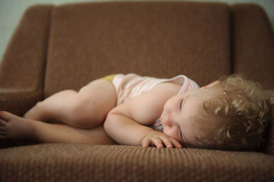 Cute baby lying on sofa at home