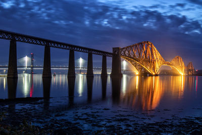 View of bridge over river at night