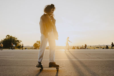 Young woman standing on skateboard in park