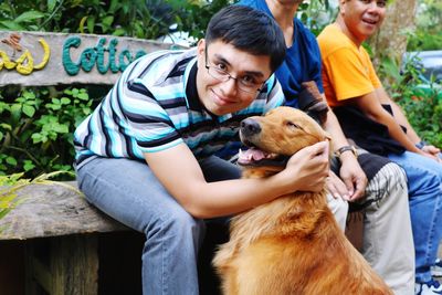 Portrait of man with dog sitting outdoors