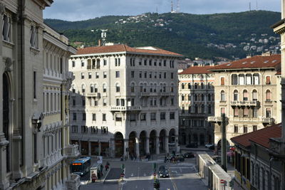 Trieste is a city and seaport in northeastern italy. the photo depicts buildings during golden aura.