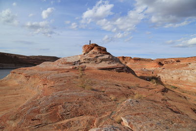 Scenic view of rock formation by sea against blue sky