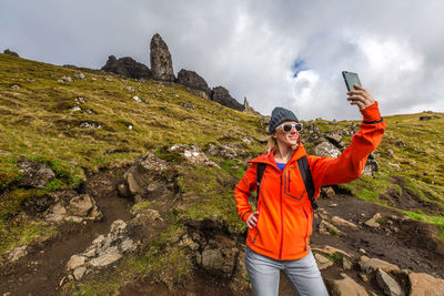 Woman taking selfie while standing on mountain