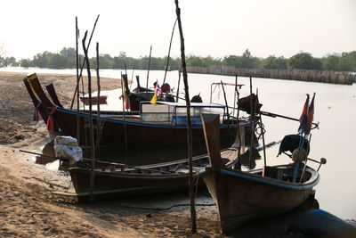 Boat moored on beach against sky