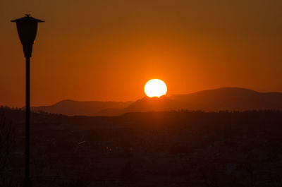 Scenic view of silhouette mountain against orange sky