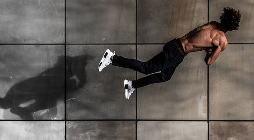 Rear view of shirtless man lying on floor