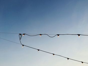 Low angle view of lights hanging against clear sky