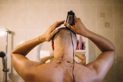 Midsection of shirtless man holding bathroom