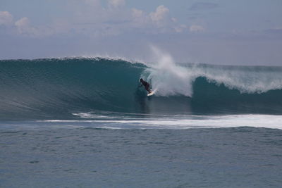 Man surfing in sea against sky