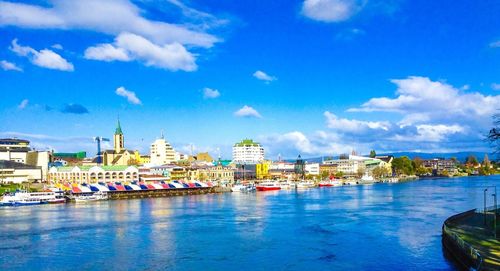 Boats in river with buildings in background