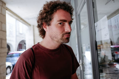 Young man looking through window