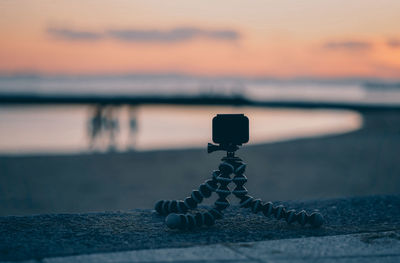 Close-up of pebbles on beach against sky during sunset