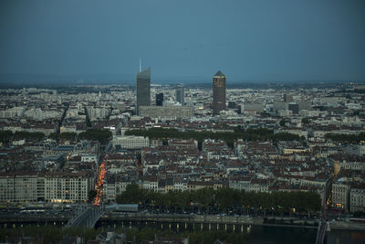 Aerial view of buildings in city at dusk