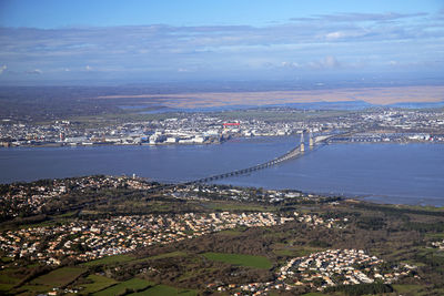 High angle view of city by sea against sky