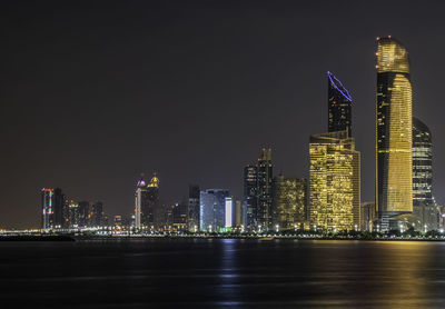 Illuminated buildings against sky at night