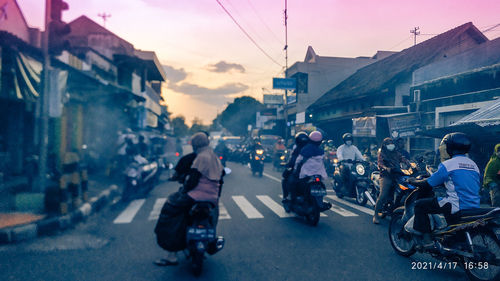 People riding motorcycle on road in city