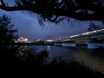 View of bridge over river at night