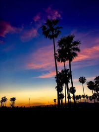 Silhouette palm trees against sky during sunset