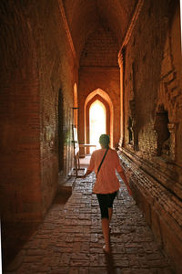 Rear view of woman standing amidst buildings