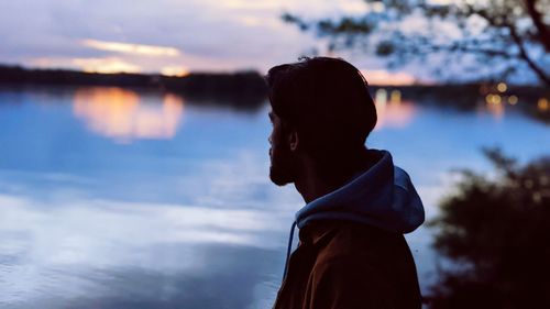 Portrait of silhouette man standing by lake against sky