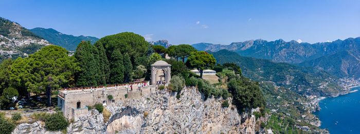 Panoramic view of trees and mountains against blue sky