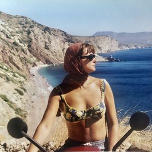 Portrait of young woman wearing sunglasses while standing at beach