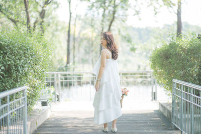 Full length of woman standing against trees