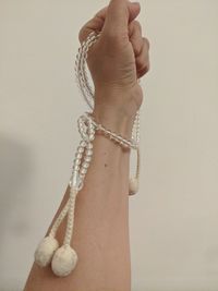 Close-up of woman holding hands against white background