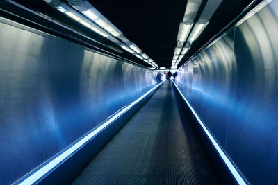 Interior of illuminated subway moving walkway