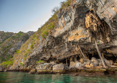 Rock formation in sea against sky