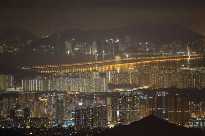 Illuminated skylines with bridge and mountains at night