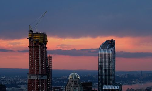 Modern buildings against sky during sunset