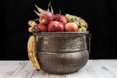 Close-up of fruits on table against black background