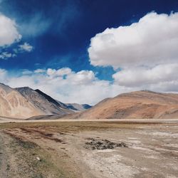 Scenic view of mountains against cloudy blue sky