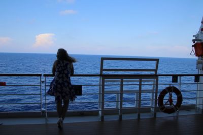 Rear view of woman looking at sea against sky