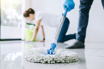 Low section of man cleaning floor with mop