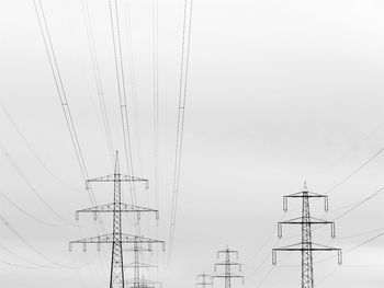 Low angle view of electricity pylon against clear sky