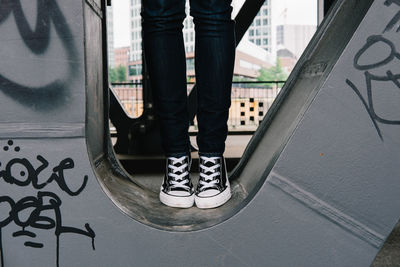 Low section of person standing on metal structure