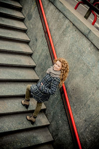 High angle view of happy young woman standing on steps