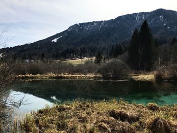 Scenic view of lake by mountains against sky