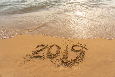 High angle view of text on sand at beach